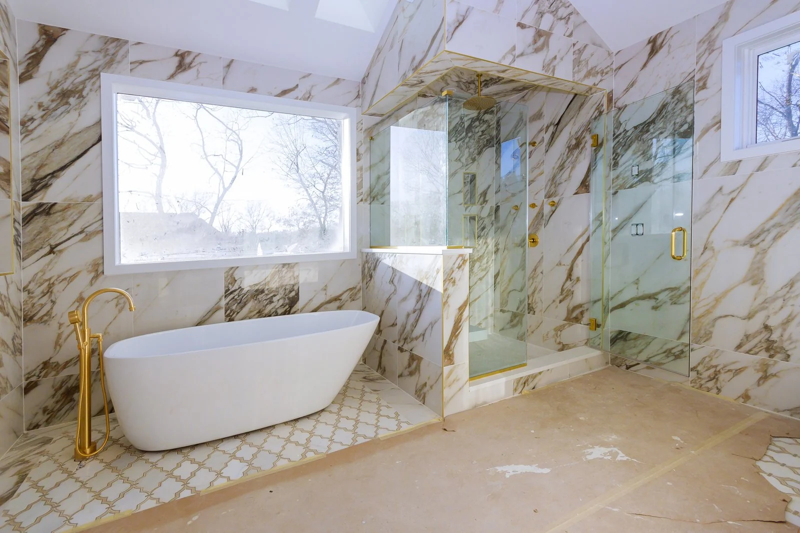 Luxury marble bathroom renovation with brass fixtures